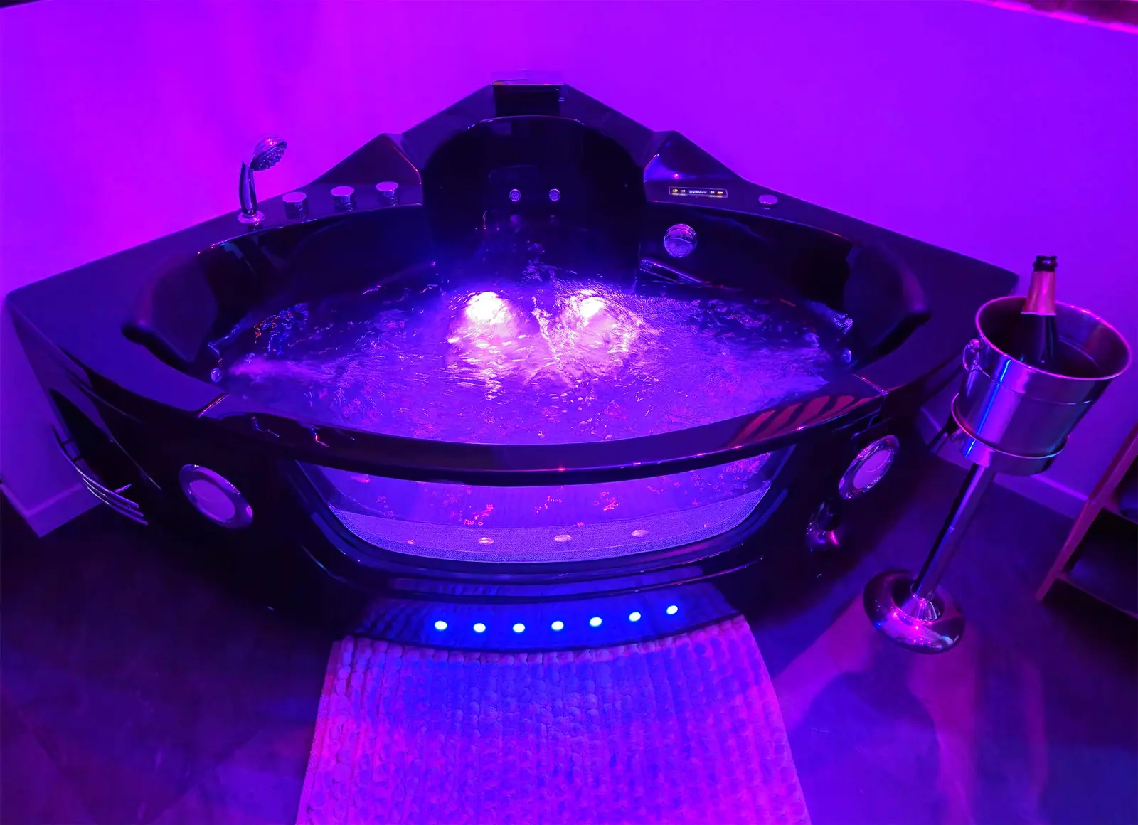 Baignoire balnéo privative TIJUGO éclairée en violet à Clermont-Ferrand